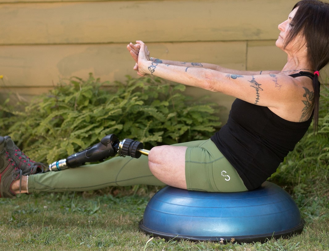 Woman with limb loss working out core.