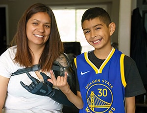 Woman with prosthetic arm smiling with son.
