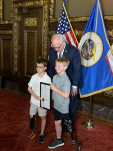 Logan Pieper and a friend pose for a picture with Minnesota Governor Tim Walz.