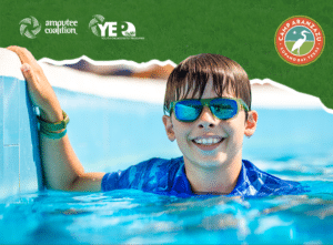 Young bou in a pool wearing green and blue sunglasses