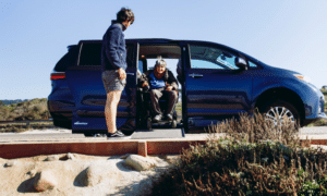 Wheelchair accessible van with a ramp. A woman in a wheelchair is shown coming out.
