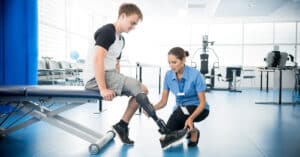 Healthcare worker looking at patient's prosthetic leg.